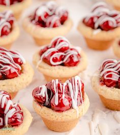 some very tasty looking pastries with red and white icing on them sitting on a table