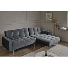 a grey sectional sofa with gold legs in a living room