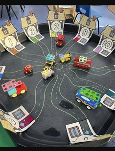 a black tray with cars and trucks on it in front of a table that has numbered numbers