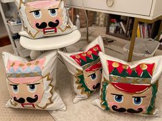 four pillows that have been made to look like cartoon characters on them, sitting in front of a dresser