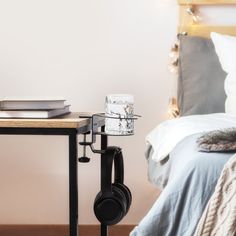 a nightstand with headphones on it next to a bed