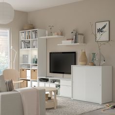 a living room filled with furniture and a flat screen tv on top of a entertainment center