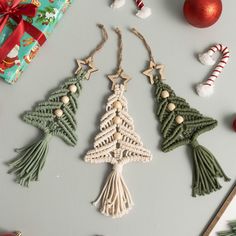 three christmas tree ornaments on a table next to some candy canes and other holiday decorations