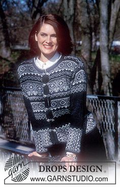 a woman standing in front of a bench wearing a black and white sweater with an intricate design