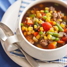 a close up of a bowl of soup with meat and veggies on a plate