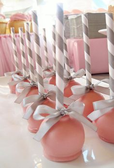 pink and silver cake pops with bows on them are lined up next to each other