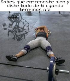 a man laying on the ground while holding a barbell