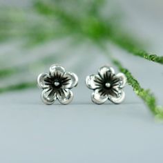 These Cherry Blossom Stud Earrings feature a beautiful nature-inspired flower design. In Japan, the Cherry Blossom is a reminder that life is beautiful, but can be very short, and that we must enjoy all our moments. We are happy to create these earrings for you in a variety of finishes. These delicate Sterling Silver stud earrings measure 7 mm in width, and have a 4 mm (.15 inch) long sterling silver post. They come complete with Sterling silver ear backs and a box appropriate for gift giving. T Sterling Silver Birth Flower Earrings, Silver Nature-inspired Flower Earrings For Gift, Nature-inspired Sterling Silver Flower Earrings, Nature-inspired Flower Sterling Silver Earrings, Nature-inspired Hypoallergenic Flower Earrings For Gift, Nature-inspired Adjustable Flower Earrings, Adjustable Flower-shaped Nature-inspired Earrings, Nature-inspired Hypoallergenic Flower Earrings, Nature-inspired Flower Earrings