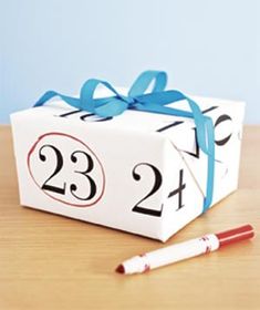 a small white box with blue ribbon and numbers on it next to a marker that says twenty two