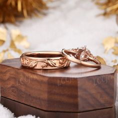 two wedding rings sitting on top of a wooden box