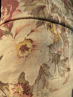 a close up of a bed with a flowered comforter