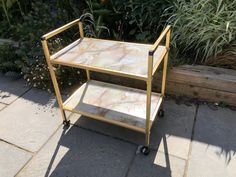 a marble topped serving cart sitting on top of a sidewalk