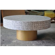 a white and gold coffee table sitting on top of a cement floor