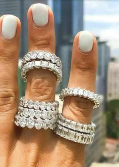 a woman's hand with three rings on it and one is holding the other