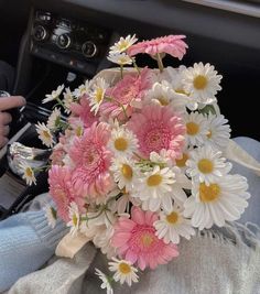 a bouquet of daisies in the passenger seat of a car