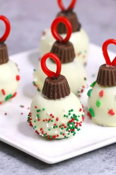 white chocolate covered desserts with red and green sprinkles on a plate