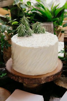 a white frosted cake sitting on top of a wooden table