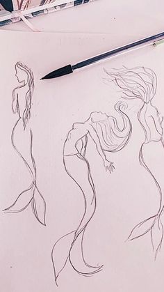 a pencil drawing of two mermaids on paper