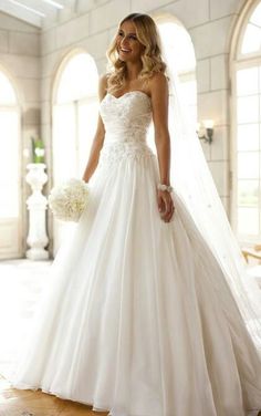 a woman in a white wedding dress holding a bouquet