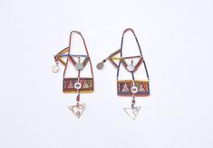 These African old tribal beaded earrings from the Masai Tribe of Kenya and would be a stunning addition to any jewelry collection. The intricate design and vibrant colors make them a true statement piece. The earrings are made from wire and beads and feature a unique aluminum metal. The earrings are collectors items and are perfect for both men and women. The main stone is glass and the ear area is the lobe. The beaded style and multicolor design are a beautiful representation of African ethnic and regional style of the Masai of Kenya. These earrings are a must-have for anyone who loves tribal jewelry. Museum Quality 6 1/4 Inches Long 3.5 Inches Wide Middle Top 2 Inches Wide Bottom Dangle 1.5 Inches Long AT BACARA WE STAND BEHIND ALL OF OUR MERCHANDISE. FULL MONEY BACK GUARANTEE WILL BE PR Unique Dangling Beads For Festivals, Bohemian Beaded Earrings With Colorful Beads, Traditional Round Beaded Earrings For Festival, Bohemian Drop Earrings With Polished Beads, Unique Festival Earrings With Dangling Beads, Unique Beaded Earrings For Festivals, Traditional Large Beaded Drop Earrings, Traditional Large Bead Drop Earrings, Unique Beaded Earrings With Tiny Beads For Festivals