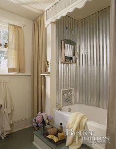 a bath room with a tub a window and towels on the shelf next to it