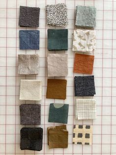 several pieces of fabric laid out on a gridded cloth mat with squares and rectangles