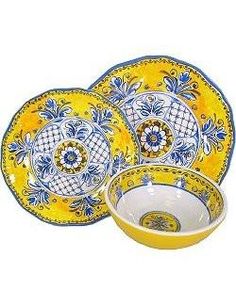 three yellow and blue plates with designs on them, one has a bowl in the middle