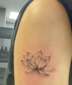 a woman with a tattoo on her arm has a lotus flower tattooed on her left shoulder