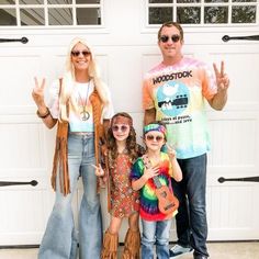 a man, woman and two children posing in front of a garage door