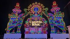 the carnival magic sign is lit up at night with colorful lights on it's sides