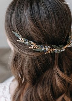 a woman with long brown hair wearing a gold leaf headpiece