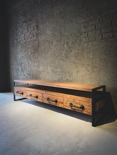 a large wooden table with drawers in front of a brick wall and light coming from behind it