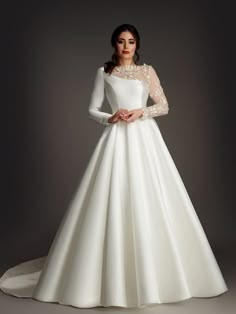 a woman in a white wedding dress with long sleeves