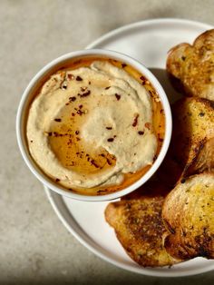 a white plate topped with bread and dip