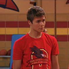 the young man is wearing a red shirt with an eagle on it's chest