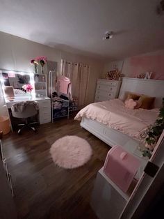 a bedroom with a bed, desk and mirror on the wall next to hardwood flooring