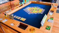 a wooden table topped with a board game on top of a hard wood floor next to a chair