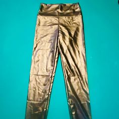 a pair of metallic pants sitting on top of a blue surface