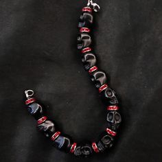 "If you're like me, you love skulls. So show your love with this skull bracelet! This bracelet features black howlite stone skulls and red stone crystal spacers, and is closed with a silver stainless steel lobster claw clasp. It comes in 3 sizes: Large - Fits wrists you to 7 1/2\" around Medium - Fits wrists up to 6 1/2\" around Small - Fits wrists up to 5 1/2\" around. If you need a different size, let me know and I will see what I can do. Make sure to check out my shop, PopBangBoom, for all so Punk Style Black Beaded Bracelets For Gift, Edgy Black Beaded Jewelry, Edgy Black Handmade Bracelets, Edgy Handmade Black Bracelets, Black Skull Bracelets For Festival, Gothic Black Beaded Bracelets For Halloween, Emo Black Skull Jewelry, Handmade Black Gothic Bracelets, Gothic Black Beaded Bracelets