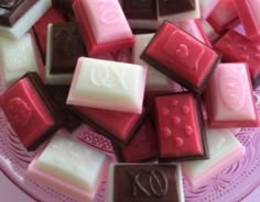 many different types of chocolates on a pink plate with the number twenty nine in it