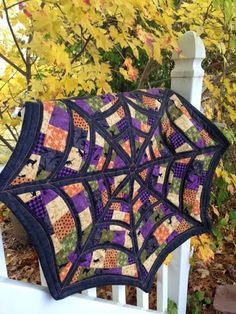 a quilted umbrella sitting on top of a white fence