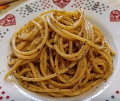 a white plate topped with pasta covered in sauce and parmesan sprinkles