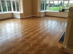 an empty room with wooden floors and windows