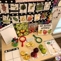 a table topped with lots of fruits and veggies next to a bulletin board