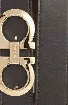 A removable double-Gancio buckle adds golden sheen to a handsome belt crafted from high-quality leather. 1 1/4" belt width; 3 1/2" x 1 3/4" buckle Leather Made in Italy Designer Formal Belt With Removable Buckle, Designer Formal Belt With Removable Feature, Designer Formal Belts With Removable Belt, Designer Belts With Gold-tone Hardware For Business, Designer Business Belts With Gold-tone Hardware, Elegant Black Belt Buckles With Metal Logo, Leather Belts With Gold-tone Rectangular Buckle, Luxury Black Belt Buckles With Gold-tone Hardware, Designer Belts With Buckle Closure For Business