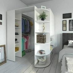 a bedroom with white walls and flooring has an open closet in the corner that is next to a bed