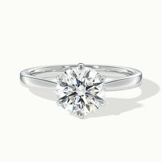 a round brilliant cut diamond engagement ring on a white background with the center stone visible