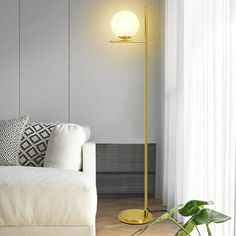 a living room with a white couch and yellow floor lamp