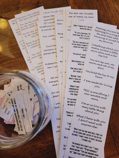 several pieces of paper sitting on top of a wooden table next to a glass bowl