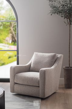 a chair sitting in front of a window next to a potted plant